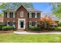 Lovely brick home showcasing manicured landscaping, black shutters, and a charming front entrance at 3909 Black Sycamore Dr, Charlotte, NC 28226