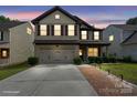 Charming two-story home with a two-car garage, manicured landscaping, and a welcoming brick walkway at 392 Winecoff Woods Nw Dr, Concord, NC 28027
