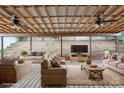 Inviting covered patio with comfortable seating, ceiling fans, and a view of the backyard's natural slope at 392 Winecoff Woods Nw Dr, Concord, NC 28027
