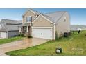 Side view of a two-story home featuring a spacious two-car garage and verdant lawn at 3985 Village Nw Blvd, Conover, NC 28613