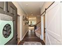 Inviting foyer featuring hardwood floors, a modern barn door, and decorative wall art at 4018 Harmattan Dr, Denver, NC 28037