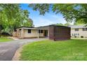 Single-story home featuring brick accents, a carport, and mature trees at 467 16Th Nw Ave, Hickory, NC 28601