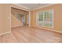 An inviting living room features a staircase, large window, neutral walls, and light-colored wood flooring at 5607 Fulton Ridge Dr, Indian Trail, NC 28079