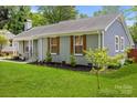 Charming one-story home with a beautifully landscaped front yard and gray brick exterior at 6406 Old Meadow Rd, Charlotte, NC 28227