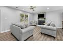 Cozy living room with fireplace, plush seating, ceiling fan, and natural light at 6406 Old Meadow Rd, Charlotte, NC 28227