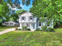Charming two-story home with light blue siding, dark shutters, green lawn, and mature trees at 8514 Timber Crest Cir, Charlotte, NC 28226