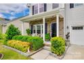Inviting front porch with brick accents, decorative plants, and seating, enhancing the home's curb appeal at 922 Bunker Trce, Rock Hill, SC 29730
