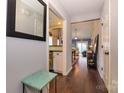 Hallway featuring wood floors and decorative mirror, leading to living spaces and kitchen at 9239 N Vicksburg Park Ct, Charlotte, NC 28210