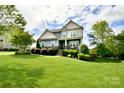 Charming two-story home boasts lush landscaping and a welcoming front porch with rocking chairs at 104 Rockridge Point Dr, Mooresville, NC 28117