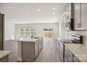 Modern kitchen features stainless steel appliances, an island, and granite countertops at 116 Obadiah Ct, Mooresville, NC 28115