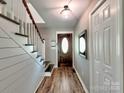 Warm entryway featuring hardwood floors, a wooden staircase, and a decorative front door at 11850 Sugar Hill Rd, Davidson, NC 28036