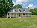 Charming two-story home with a welcoming front porch, classic windows, and a well-maintained green lawn at 11850 Sugar Hill Rd, Davidson, NC 28036