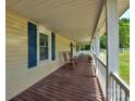 Relaxing covered front porch with wooden rocking chairs and view of the green lawn at 11850 Sugar Hill Rd, Davidson, NC 28036
