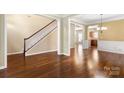 Spacious living room with gleaming hardwood floors, staircase, and a view into adjacent rooms at 12824 Harvest Time Ct, Charlotte, NC 28278