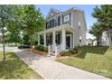 Inviting two-story home featuring a covered porch, landscaped garden beds, and a neatly manicured front yard at 13107 Heath Grove Dr, Huntersville, NC 28078