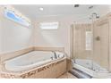 Elegant bathroom with a jacuzzi tub, a separate glass-enclosed shower, and tile flooring at 1724 Windy Rush Ln, Gastonia, NC 28054