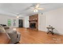 Cozy living room with a brick fireplace, hardwood floors, and access to an outdoor deck at 1724 Windy Rush Ln, Gastonia, NC 28054