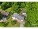 Aerial view of a home with a well-maintained lawn, detached garage and surrounded by lush trees at 1822 N New Hope Rd, Gastonia, NC 28054