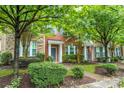 Charming brick townhome featuring a well-manicured lawn and lush greenery at 18460 W Catawba Ave, Cornelius, NC 28031