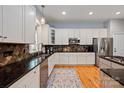 Beautiful kitchen featuring stainless steel appliances, dark countertops, tile backsplash, and wood floors at 189 Mills Ln, Fort Mill, SC 29708