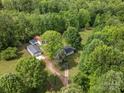 Aerial view of wooded property with a house, two outbuildings, and a long driveway at 195 Bluebird Ln, Salisbury, NC 28146