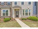 Inviting entrance to a townhome, featuring a wreath on the front door and manicured landscaping at 19812 Elise Caroline Aly, Davidson, NC 28036