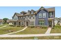 View of townhomes with unique architectural styles, showcasing inviting entryways, well-kept lawns, and tidy landscaping at 19812 Elise Caroline Aly, Davidson, NC 28036