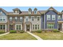 Townhome exterior showcasing a well-manicured lawn and varied facade offering appealing curb appeal at 19812 Elise Caroline Aly, Davidson, NC 28036
