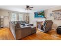 Bright living room with a fireplace, hardwood floors, and large windows providing natural light at 211 General Stonewall Jackson Dr, Stanley, NC 28164