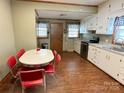 Bright kitchen with white cabinets, granite countertops, modern appliances, eat-in dining, and wood look flooring at 211 Spruce St, Badin, NC 28009
