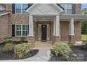 Welcoming front porch featuring brick columns, black mulch landscaping, and elegant front door at 2185 Loire Valley Dr, Fort Mill, SC 29707