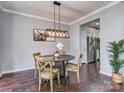 Charming dining area with modern light fixture, hardwood floors, and an adjacent kitchen at 2331 Whitford Ln, Charlotte, NC 28210