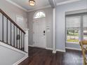 Light-filled foyer with hardwood floors, staircase, and a view to the outdoors through a window at 2331 Whitford Ln, Charlotte, NC 28210