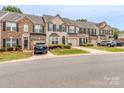 A row of townhomes featuring brick and siding exteriors, dark shutters, and well-maintained landscaping at 2331 Whitford Ln, Charlotte, NC 28210