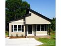 Inviting exterior with black trim, neutral siding, front porch, and new concrete driveway at 256 Lincoln Sw St # 1, Concord, NC 28025