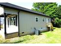 Rear view of the home with a small wooden deck and updated siding at 256 Lincoln Sw St # 1, Concord, NC 28025