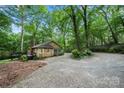 View of the house's side featuring a cozy deck in a private, wooded lot with mature trees and long driveway at 3000 Low Gap Rd, Waxhaw, NC 28173