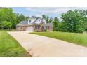 A large brick home with an attached garage and a long driveway leading up to the property at 3178 Newcastle Dr # 42, Rock Hill, SC 29732