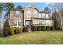 Charming two-story home with stone accents, well-manicured lawn, and lush landscaping at 4095 Harmattan Dr, Denver, NC 28037