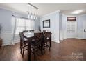 Cozy dining room featuring hardwood floors, a stylish table with seating for six, and elegant lighting fixtures at 5003 Singletree Ln, Indian Trail, NC 28079