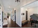 Inviting foyer featuring gleaming hardwood floors, modern lighting, and a glimpse into the open-concept living space at 562 Preservation Dr, Fort Mill, SC 29715
