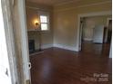 Cozy living room features a fireplace, fresh paint and trim, plus beautiful hardwood floors at 607 Lee Ave, Wadesboro, NC 28170