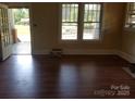 Bright living room featuring hardwood floors, large windows, and an open doorway at 607 Lee Ave, Wadesboro, NC 28170