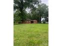 This backyard features a charming brick home surrounded by mature trees, offering a serene and private setting at 610 E Maryland Ave, Bessemer City, NC 28016
