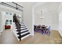 Inviting entryway with staircase and view of dining room featuring modern table and chairs at 7160 Sumters Camp Trl, Indian Land, SC 29707