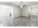 Open-concept floor plan with view into living room and kitchen with grey wood floors and neutral walls at 8339 Hornwood Ct, Charlotte, NC 28215