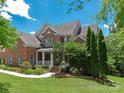 Landscaped front yard, well-manicured lawn and mature trees surrounding this beautiful brick home at 8914 Landsdowne Ave, Harrisburg, NC 28075