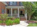 Close-up of the home's entry with a brick walkway, white porch columns, and garden beds at 8914 Landsdowne Ave, Harrisburg, NC 28075