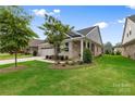 Beautifully landscaped yard with a view of the home's brick exterior and inviting front porch at 9109 Liberty Hill Dr, Mint Hill, NC 28227