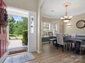 Inviting dining room featuring hardwood floors, elegant chandelier, and a large window for natural light at 1051 Streamlet Way, Monroe, NC 28110